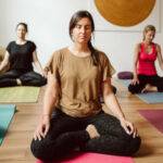 Teilnehmerinnen des Yogacoaching Workshops Selbstliebe und Selbstwert in Potsdam bei Marie Rohde in der Yogaübung Schneidersitz.
