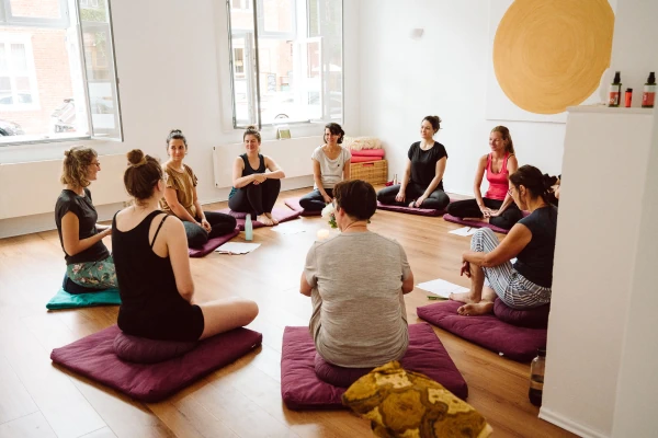 Marie Rohde von vispharana yoga und Teilnehmerinnen des Yogacoaching Workshops Selbstliebe und Selbstwert sitzen im Yogaraum in Potsdam im Kreis.