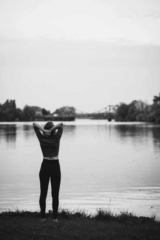 Marie Rohde von vispharana yoga steht voll Zuversicht und Resilienz am Wasser im Park Babelsberg in Potsdam.